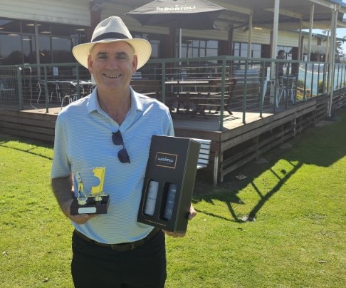 Peter Sheridan with the spoils after acing the 13th hole at The Island.